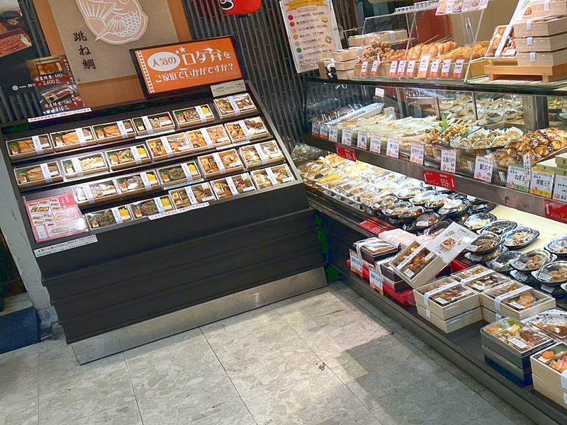 跳ね鯛 伊勢丹浦和店の売場（ロケ弁の棚と惣菜のケース）